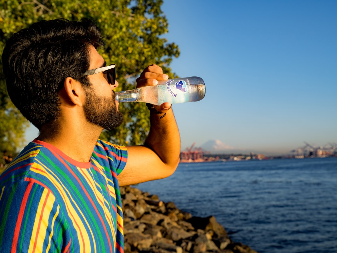 a-man-drinking-water-from-a-water-bottle-admxgfl0n8i